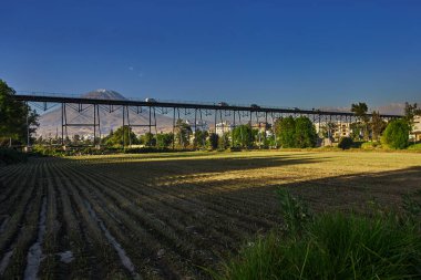 Arka planda yanardağ sisi, Chachani ve Pichu Pichu olan Arequipa yakınlarındaki tarım arazileri.