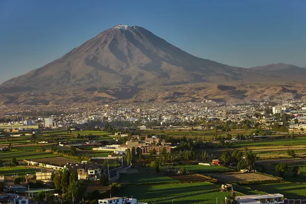 Arka planda yanardağ sisi, Chachani ve Pichu Pichu olan Arequipa yakınlarındaki tarım arazileri.