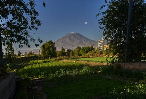 Arka planda yanardağ sisi, Chachani ve Pichu Pichu olan Arequipa yakınlarındaki tarım arazileri.