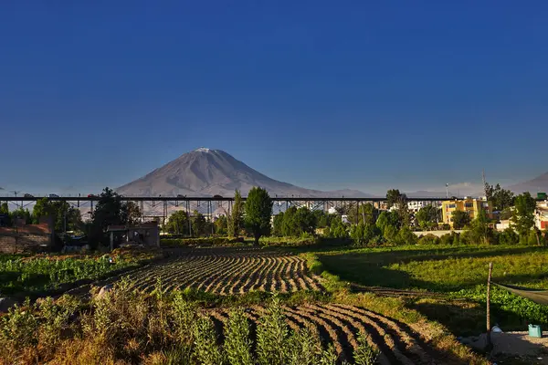 Arka planda yanardağ sisi, Chachani ve Pichu Pichu olan Arequipa yakınlarındaki tarım arazileri.