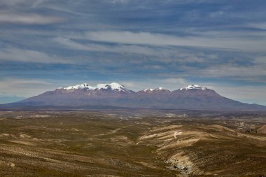 Arequipa 'nın tepelerinde, Chachani' nin karla kaplı yamaçları eski bir nöbetçi gibi nöbet tutuyor. 6057 metrede, bu hareketsiz dev volkanik tarihini pas rengi kaya katmanları halinde takıyor.