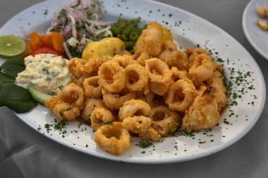 Peru Chicharrn de Calamar, genellikle aperatif ya da aperatif olarak sunulan bol yağda kızartılmış kalamar içeren lezzetli bir yemektir. Kıtır kıtır dokusuyla ve aromalı baharatıyla bilinir..