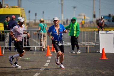 Demir Adam 70.3 Lima 'nın son turlarında koşan sporcular, sadece hayaller peşinde koşmakla kalmaz, aynı zamanda yaşarlar da. Gözyaşları, ter ve kırılmaz ruh bitiş çizgisine giden yolu işaretler..