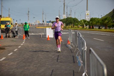 Demir Adam 70.3 Lima 'nın son turlarında koşan sporcular, sadece hayaller peşinde koşmakla kalmaz, aynı zamanda yaşarlar da. Gözyaşları, ter ve kırılmaz ruh bitiş çizgisine giden yolu işaretler..
