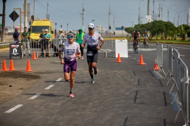 Demir Adam 70.3 Lima 'nın son turlarında koşan sporcular, sadece hayaller peşinde koşmakla kalmaz, aynı zamanda yaşarlar da. Gözyaşları, ter ve kırılmaz ruh bitiş çizgisine giden yolu işaretler..