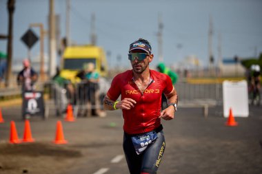 Demir Adam 70.3 Lima 'nın son turlarında koşan sporcular, sadece hayaller peşinde koşmakla kalmaz, aynı zamanda yaşarlar da. Gözyaşları, ter ve kırılmaz ruh bitiş çizgisine giden yolu işaretler..