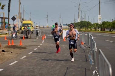 Demir Adam 70.3 Lima 'nın son turlarında koşan sporcular, sadece hayaller peşinde koşmakla kalmaz, aynı zamanda yaşarlar da. Gözyaşları, ter ve kırılmaz ruh bitiş çizgisine giden yolu işaretler..
