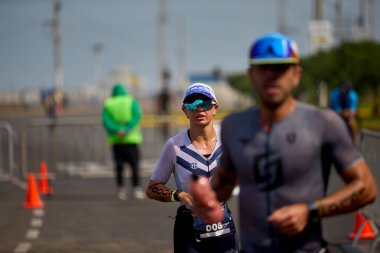 Demir Adam 70.3 Lima 'nın son turlarında koşan sporcular, sadece hayaller peşinde koşmakla kalmaz, aynı zamanda yaşarlar da. Gözyaşları, ter ve kırılmaz ruh bitiş çizgisine giden yolu işaretler..