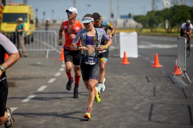 Demir Adam 70.3 Lima 'nın son turlarında koşan sporcular, sadece hayaller peşinde koşmakla kalmaz, aynı zamanda yaşarlar da. Gözyaşları, ter ve kırılmaz ruh bitiş çizgisine giden yolu işaretler..