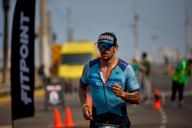 Demir Adam 70.3 Lima 'nın son turlarında koşan sporcular, sadece hayaller peşinde koşmakla kalmaz, aynı zamanda yaşarlar da. Gözyaşları, ter ve kırılmaz ruh bitiş çizgisine giden yolu işaretler..