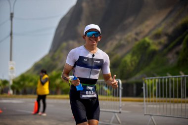 Demir Adam 70.3 Lima 'nın son turlarında koşan sporcular, sadece hayaller peşinde koşmakla kalmaz, aynı zamanda yaşarlar da. Gözyaşları, ter ve kırılmaz ruh bitiş çizgisine giden yolu işaretler..