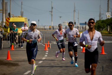 Demir Adam 70.3 Lima 'nın son turlarında koşan sporcular, sadece hayaller peşinde koşmakla kalmaz, aynı zamanda yaşarlar da. Gözyaşları, ter ve kırılmaz ruh bitiş çizgisine giden yolu işaretler..