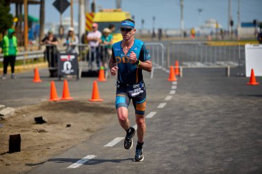 Demir Adam 70.3 Lima 'nın son turlarında koşan sporcular, sadece hayaller peşinde koşmakla kalmaz, aynı zamanda yaşarlar da. Gözyaşları, ter ve kırılmaz ruh bitiş çizgisine giden yolu işaretler..