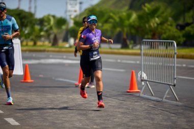 Demir Adam 70.3 Lima 'nın son turlarında koşan sporcular, sadece hayaller peşinde koşmakla kalmaz, aynı zamanda yaşarlar da. Gözyaşları, ter ve kırılmaz ruh bitiş çizgisine giden yolu işaretler..