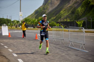 Demir Adam 70.3 Lima 'nın son turlarında koşan sporcular, sadece hayaller peşinde koşmakla kalmaz, aynı zamanda yaşarlar da. Gözyaşları, ter ve kırılmaz ruh bitiş çizgisine giden yolu işaretler..