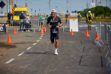 Demir Adam 70.3 Lima 'nın son turlarında koşan sporcular, sadece hayaller peşinde koşmakla kalmaz, aynı zamanda yaşarlar da. Gözyaşları, ter ve kırılmaz ruh bitiş çizgisine giden yolu işaretler..