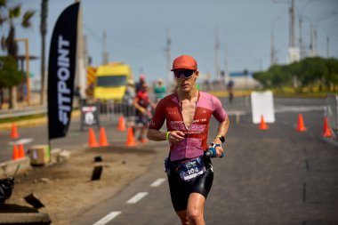 Demir Adam 70.3 Lima 'nın son turlarında koşan sporcular, sadece hayaller peşinde koşmakla kalmaz, aynı zamanda yaşarlar da. Gözyaşları, ter ve kırılmaz ruh bitiş çizgisine giden yolu işaretler..