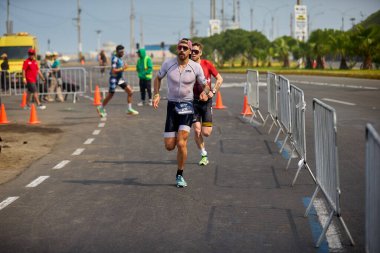 Demir Adam 70.3 Lima 'nın son turlarında koşan sporcular, sadece hayaller peşinde koşmakla kalmaz, aynı zamanda yaşarlar da. Gözyaşları, ter ve kırılmaz ruh bitiş çizgisine giden yolu işaretler..
