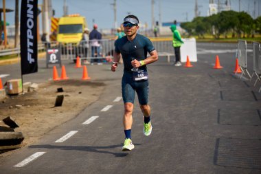 Demir Adam 70.3 Lima 'nın son turlarında koşan sporcular, sadece hayaller peşinde koşmakla kalmaz, aynı zamanda yaşarlar da. Gözyaşları, ter ve kırılmaz ruh bitiş çizgisine giden yolu işaretler..