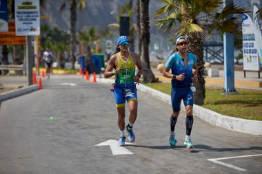 Demir Adam 70.3 Lima 'nın son turlarında koşan sporcular, sadece hayaller peşinde koşmakla kalmaz, aynı zamanda yaşarlar da. Gözyaşları, ter ve kırılmaz ruh bitiş çizgisine giden yolu işaretler..