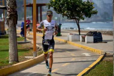 Demir Adam 70.3 Lima 'nın son turlarında koşan sporcular, sadece hayaller peşinde koşmakla kalmaz, aynı zamanda yaşarlar da. Gözyaşları, ter ve kırılmaz ruh bitiş çizgisine giden yolu işaretler..