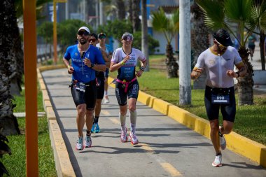 Demir Adam 70.3 Lima 'nın son turlarında koşan sporcular, sadece hayaller peşinde koşmakla kalmaz, aynı zamanda yaşarlar da. Gözyaşları, ter ve kırılmaz ruh bitiş çizgisine giden yolu işaretler..