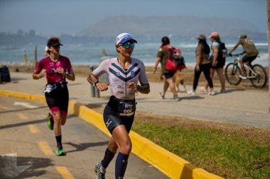 Demir Adam 70.3 Lima 'nın son turlarında koşan sporcular, sadece hayaller peşinde koşmakla kalmaz, aynı zamanda yaşarlar da. Gözyaşları, ter ve kırılmaz ruh bitiş çizgisine giden yolu işaretler..