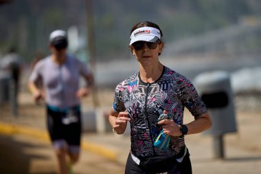 Demir Adam 70.3 Lima 'nın son turlarında koşan sporcular, sadece hayaller peşinde koşmakla kalmaz, aynı zamanda yaşarlar da. Gözyaşları, ter ve kırılmaz ruh bitiş çizgisine giden yolu işaretler..