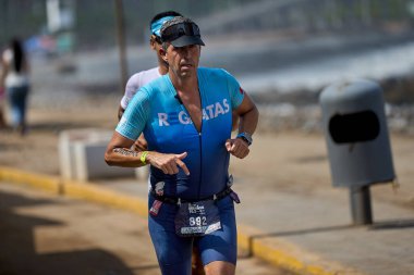 Demir Adam 70.3 Lima 'nın son turlarında koşan sporcular, sadece hayaller peşinde koşmakla kalmaz, aynı zamanda yaşarlar da. Gözyaşları, ter ve kırılmaz ruh bitiş çizgisine giden yolu işaretler..