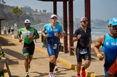 Demir Adam 70.3 Lima 'nın son turlarında koşan sporcular, sadece hayaller peşinde koşmakla kalmaz, aynı zamanda yaşarlar da. Gözyaşları, ter ve kırılmaz ruh bitiş çizgisine giden yolu işaretler..