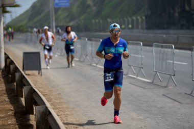 Demir Adam 70.3 Lima 'nın son turlarında koşan sporcular, sadece hayaller peşinde koşmakla kalmaz, aynı zamanda yaşarlar da. Gözyaşları, ter ve kırılmaz ruh bitiş çizgisine giden yolu işaretler..