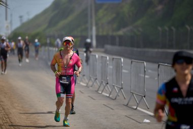 Demir Adam 70.3 Lima 'nın son turlarında koşan sporcular, sadece hayaller peşinde koşmakla kalmaz, aynı zamanda yaşarlar da. Gözyaşları, ter ve kırılmaz ruh bitiş çizgisine giden yolu işaretler..