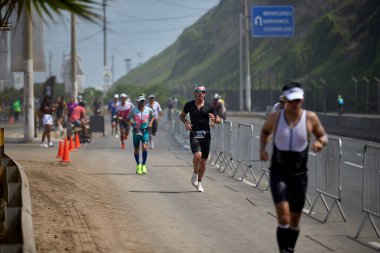 Demir Adam 70.3 Lima 'nın son turlarında koşan sporcular, sadece hayaller peşinde koşmakla kalmaz, aynı zamanda yaşarlar da. Gözyaşları, ter ve kırılmaz ruh bitiş çizgisine giden yolu işaretler..