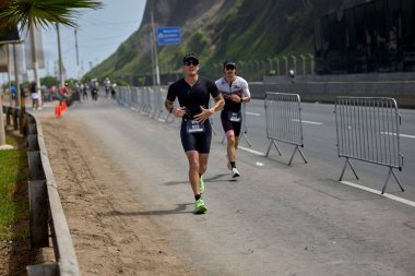 Demir Adam 70.3 Lima 'nın son turlarında koşan sporcular, sadece hayaller peşinde koşmakla kalmaz, aynı zamanda yaşarlar da. Gözyaşları, ter ve kırılmaz ruh bitiş çizgisine giden yolu işaretler..