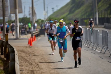 Demir Adam 70.3 Lima 'nın son turlarında koşan sporcular, sadece hayaller peşinde koşmakla kalmaz, aynı zamanda yaşarlar da. Gözyaşları, ter ve kırılmaz ruh bitiş çizgisine giden yolu işaretler..