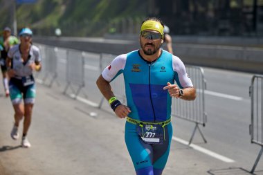 Demir Adam 70.3 Lima 'nın son turlarında koşan sporcular, sadece hayaller peşinde koşmakla kalmaz, aynı zamanda yaşarlar da. Gözyaşları, ter ve kırılmaz ruh bitiş çizgisine giden yolu işaretler..