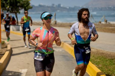 Demir Adam 70.3 Lima 'nın son turlarında koşan sporcular, sadece hayaller peşinde koşmakla kalmaz, aynı zamanda yaşarlar da. Gözyaşları, ter ve kırılmaz ruh bitiş çizgisine giden yolu işaretler..