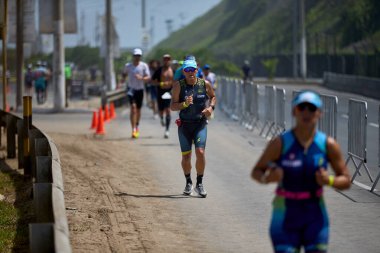 Demir Adam 70.3 Lima 'nın son turlarında koşan sporcular, sadece hayaller peşinde koşmakla kalmaz, aynı zamanda yaşarlar da. Gözyaşları, ter ve kırılmaz ruh bitiş çizgisine giden yolu işaretler..