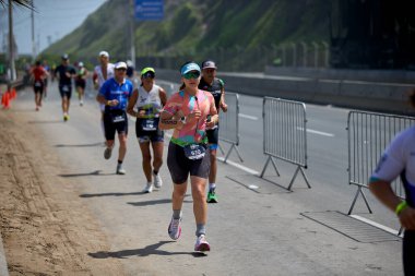 Demir Adam 70.3 Lima 'nın son turlarında koşan sporcular, sadece hayaller peşinde koşmakla kalmaz, aynı zamanda yaşarlar da. Gözyaşları, ter ve kırılmaz ruh bitiş çizgisine giden yolu işaretler..