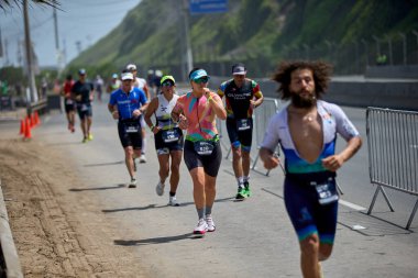 Demir Adam 70.3 Lima 'nın son turlarında koşan sporcular, sadece hayaller peşinde koşmakla kalmaz, aynı zamanda yaşarlar da. Gözyaşları, ter ve kırılmaz ruh bitiş çizgisine giden yolu işaretler..