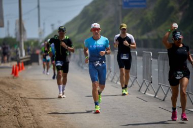Demir Adam 70.3 Lima 'nın son turlarında koşan sporcular, sadece hayaller peşinde koşmakla kalmaz, aynı zamanda yaşarlar da. Gözyaşları, ter ve kırılmaz ruh bitiş çizgisine giden yolu işaretler..