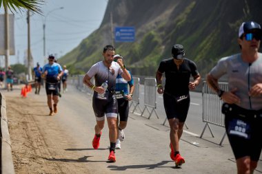 Demir Adam 70.3 Lima 'nın son turlarında koşan sporcular, sadece hayaller peşinde koşmakla kalmaz, aynı zamanda yaşarlar da. Gözyaşları, ter ve kırılmaz ruh bitiş çizgisine giden yolu işaretler..