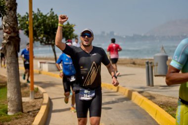 Demir Adam 70.3 Lima 'nın son turlarında koşan sporcular, sadece hayaller peşinde koşmakla kalmaz, aynı zamanda yaşarlar da. Gözyaşları, ter ve kırılmaz ruh bitiş çizgisine giden yolu işaretler..