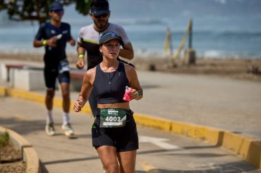 Demir Adam 70.3 Lima 'nın son turlarında koşan sporcular, sadece hayaller peşinde koşmakla kalmaz, aynı zamanda yaşarlar da. Gözyaşları, ter ve kırılmaz ruh bitiş çizgisine giden yolu işaretler..