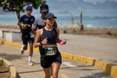 Demir Adam 70.3 Lima 'nın son turlarında koşan sporcular, sadece hayaller peşinde koşmakla kalmaz, aynı zamanda yaşarlar da. Gözyaşları, ter ve kırılmaz ruh bitiş çizgisine giden yolu işaretler..