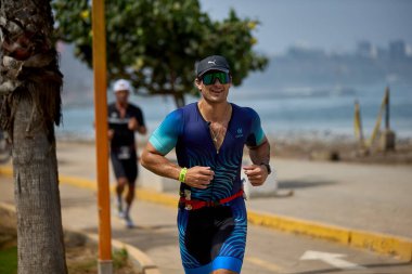 Demir Adam 70.3 Lima 'nın son turlarında koşan sporcular, sadece hayaller peşinde koşmakla kalmaz, aynı zamanda yaşarlar da. Gözyaşları, ter ve kırılmaz ruh bitiş çizgisine giden yolu işaretler..