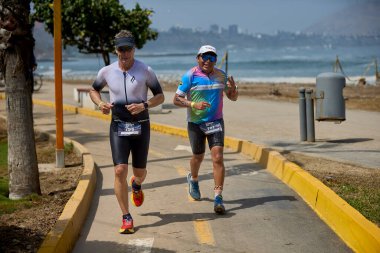 Demir Adam 70.3 Lima 'nın son turlarında koşan sporcular, sadece hayaller peşinde koşmakla kalmaz, aynı zamanda yaşarlar da. Gözyaşları, ter ve kırılmaz ruh bitiş çizgisine giden yolu işaretler..