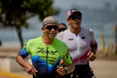 Demir Adam 70.3 Lima 'nın son turlarında koşan sporcular, sadece hayaller peşinde koşmakla kalmaz, aynı zamanda yaşarlar da. Gözyaşları, ter ve kırılmaz ruh bitiş çizgisine giden yolu işaretler..