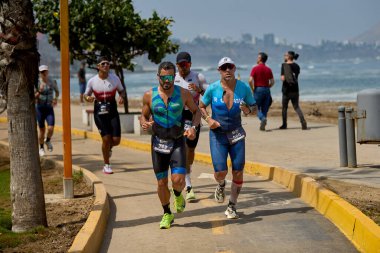 Demir Adam 70.3 Lima 'nın son turlarında koşan sporcular, sadece hayaller peşinde koşmakla kalmaz, aynı zamanda yaşarlar da. Gözyaşları, ter ve kırılmaz ruh bitiş çizgisine giden yolu işaretler..