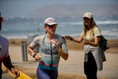 Demir Adam 70.3 Lima 'nın son turlarında koşan sporcular, sadece hayaller peşinde koşmakla kalmaz, aynı zamanda yaşarlar da. Gözyaşları, ter ve kırılmaz ruh bitiş çizgisine giden yolu işaretler..